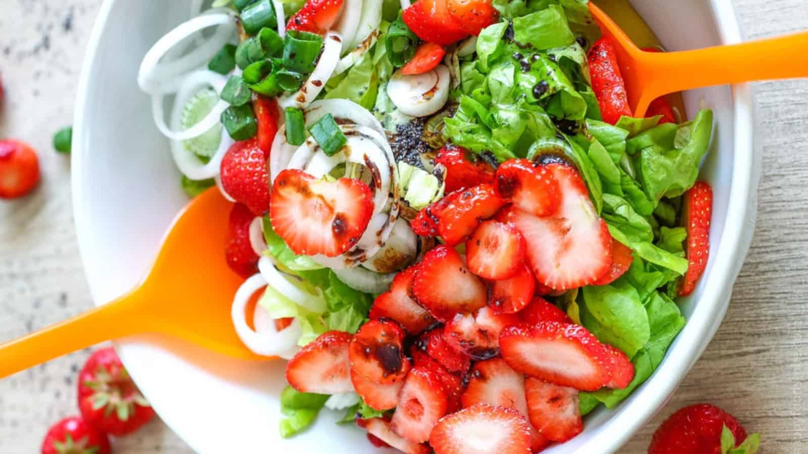 Strawberry salad with greens, sliced strawberries, and creamy poppy seed dressing.