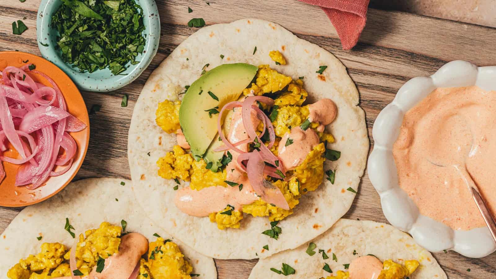 Tofu scramble tacos topped with creamy vegan chipotle sauce.