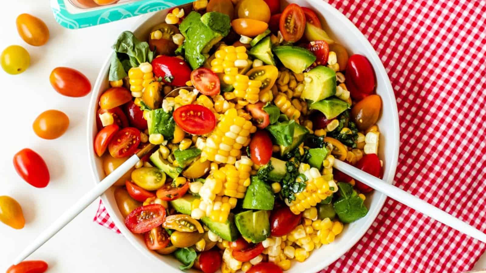 Tomato and avocado salad with sliced vegetables and a light dressing.