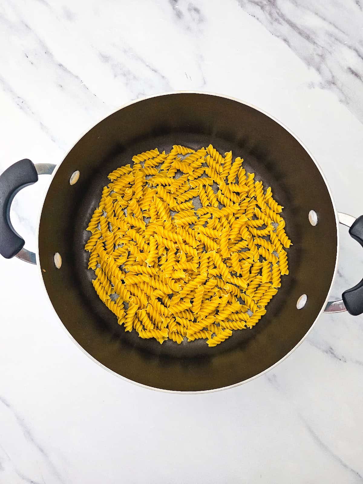 Pasta in a large pot before being added to the salad.