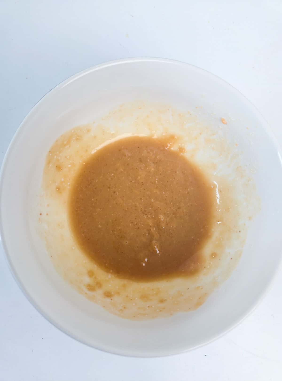 Smooth miso glaze mixture prepared in a white bowl for miso glazed eggplant.