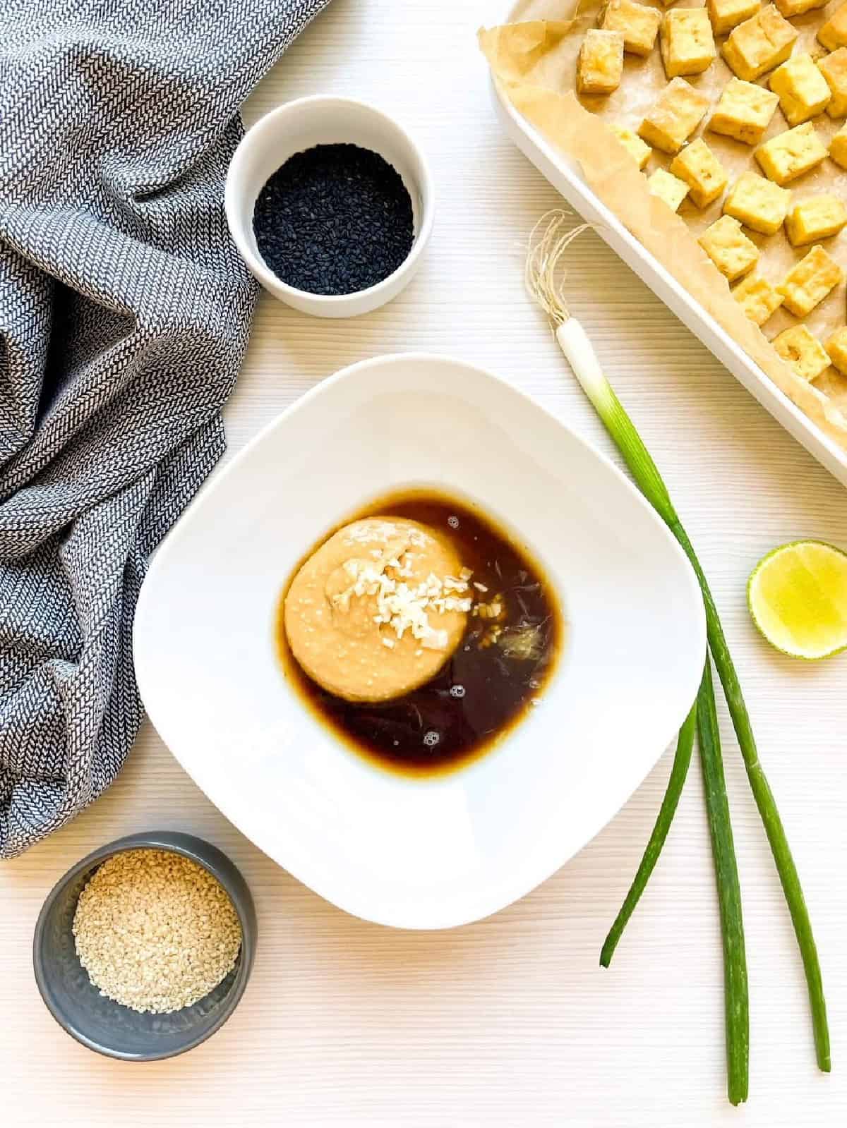 Peanut butter, soy sauce, lime juice, honey, and garlic combined in a bowl for the sauce.