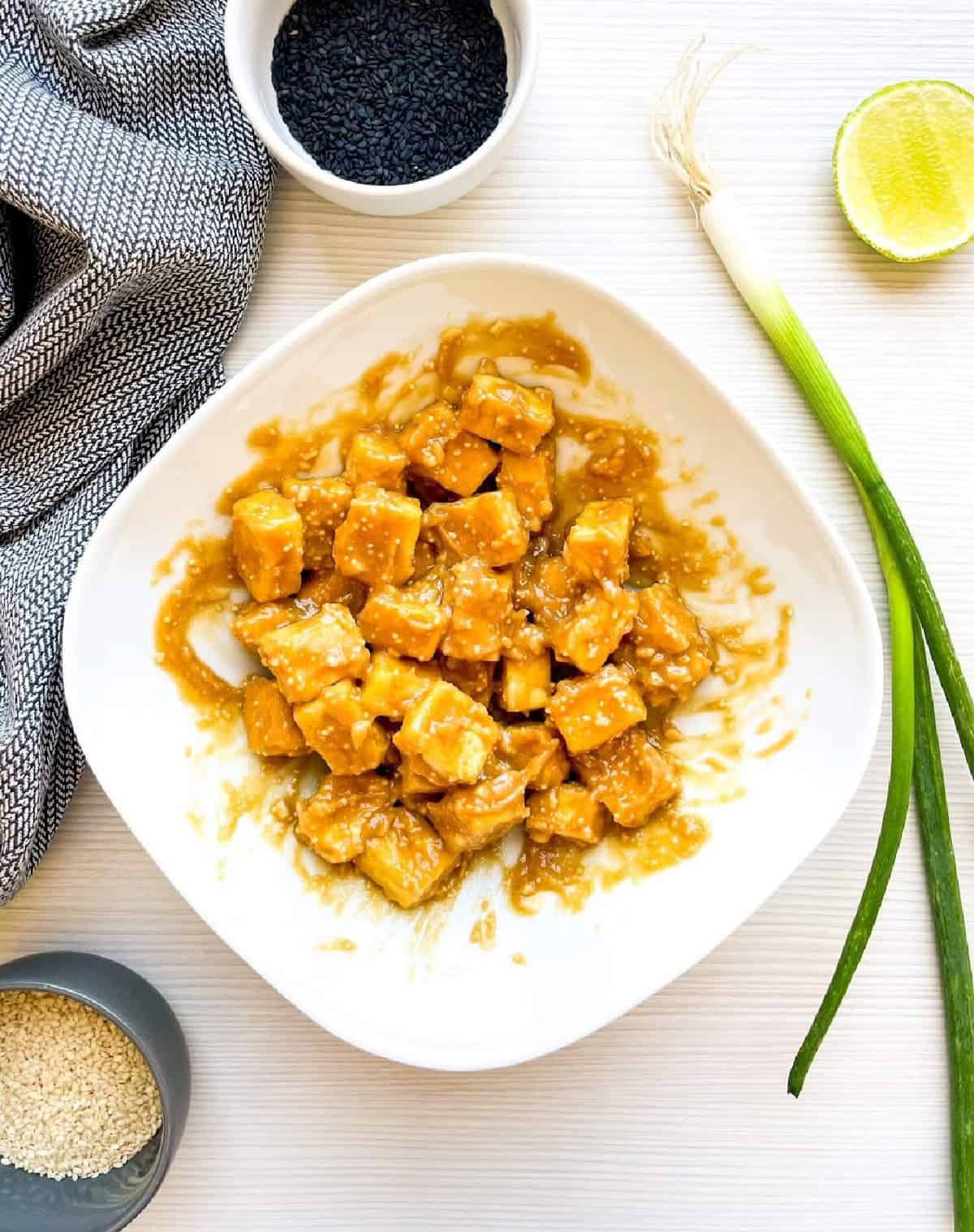 Crispy baked tofu cubes coated evenly in creamy peanut sauce.