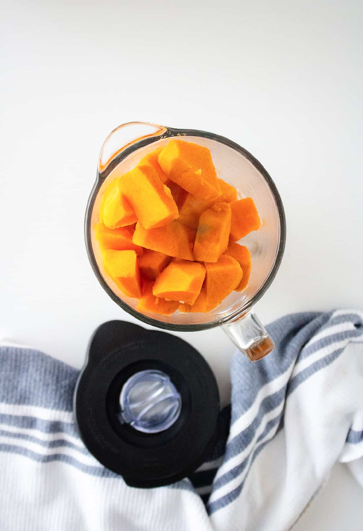 Cooked sweet potato cubes transferred to a food processor for blending.