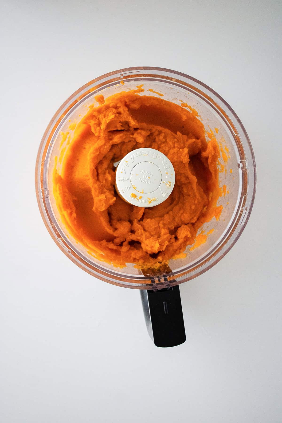 Homemade sweet potato puree is blended in a food processor until smooth and creamy.