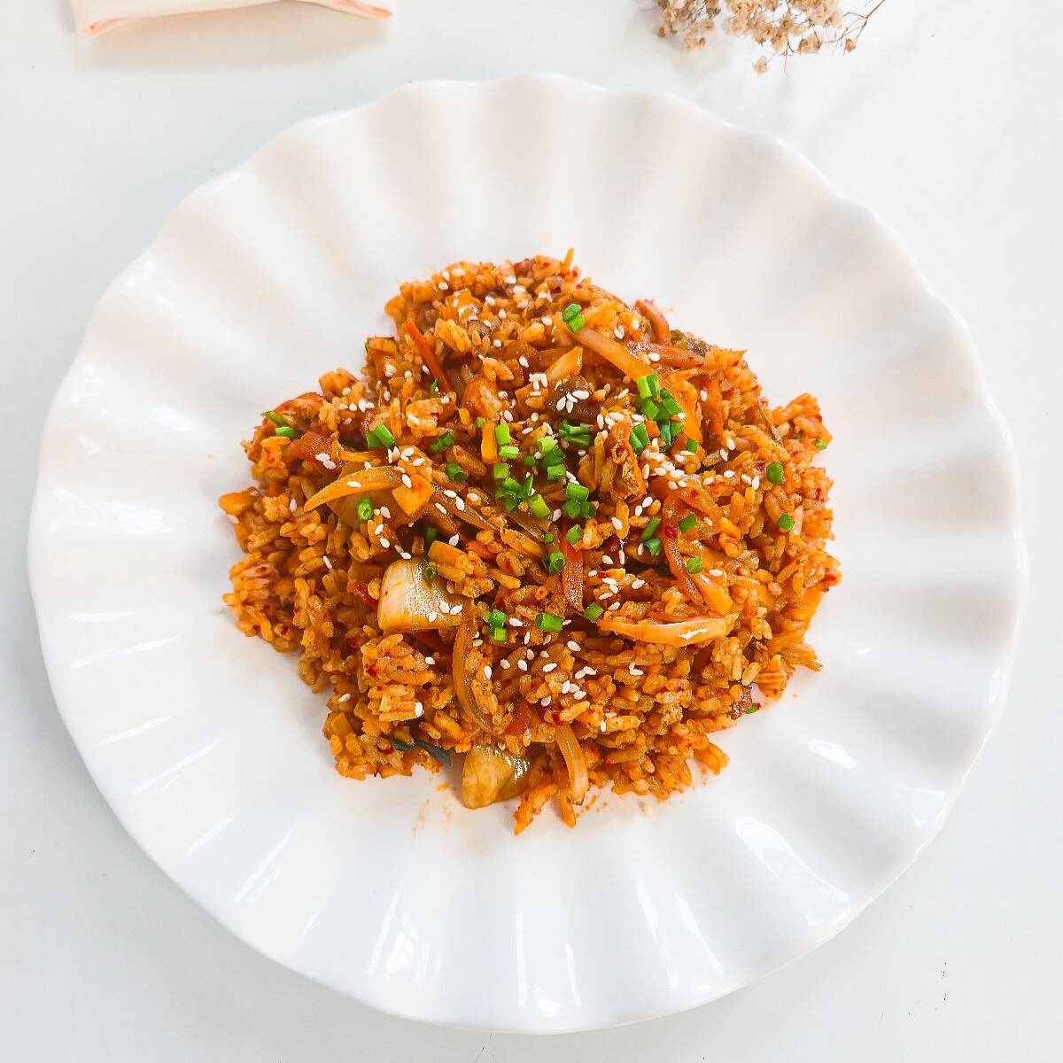Vegan kimchi fried rice on a fork showing rice, kimchi, mushrooms, and tofu pieces.