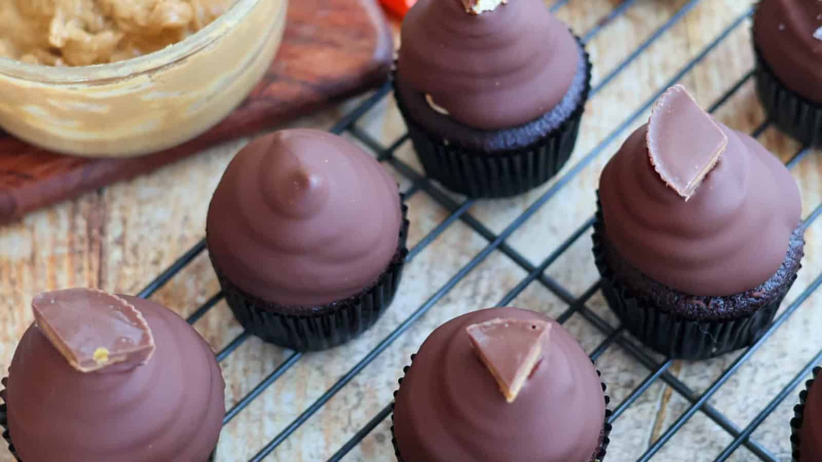 Chocolate cupcakes topped with peanut butter frosting and candy cups.