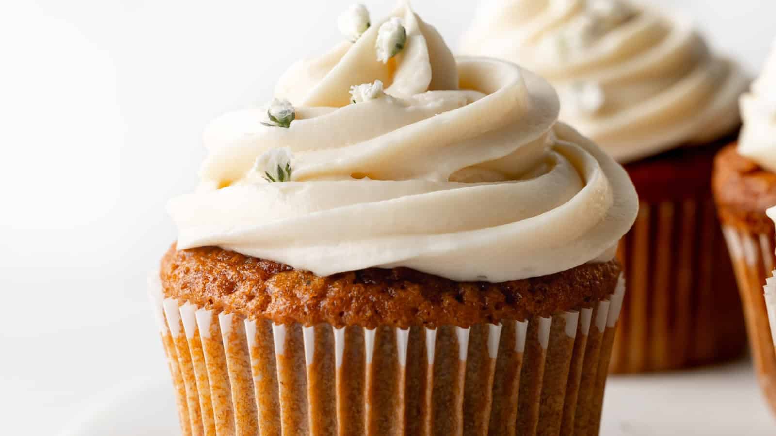 Soft gluten-free carrot cake cupcakes finished with cream cheese frosting.