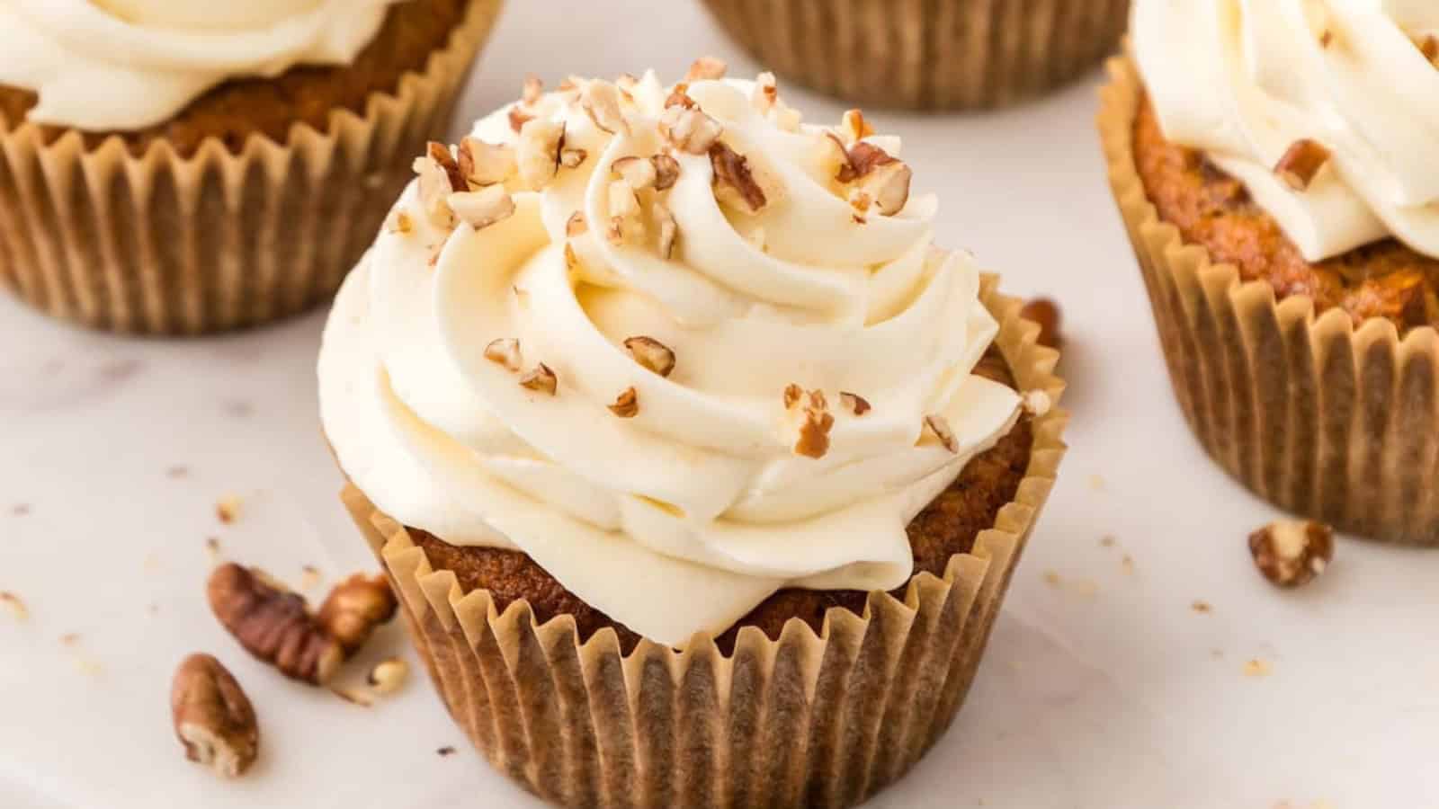 Moist carrot cake cupcakes topped with smooth cream cheese frosting.