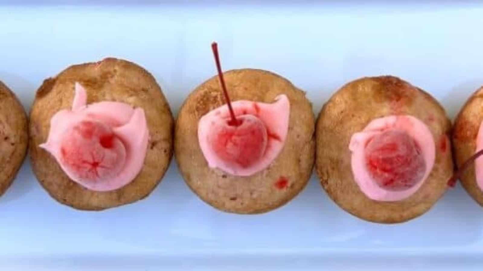 Gluten-free cherry cupcakes topped with creamy frosting and maraschino cherries.