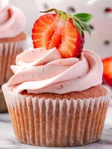 Soft gluten-free strawberry cupcakes topped with strawberry frosting.