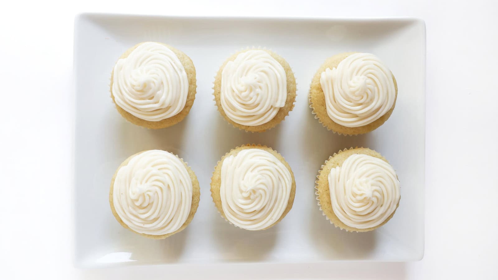 Fluffy gluten-free vanilla cupcakes topped with creamy frosting.