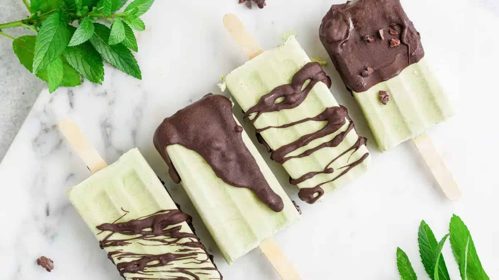 Creamy mint chocolate chip popsicles with chocolate pieces throughout.