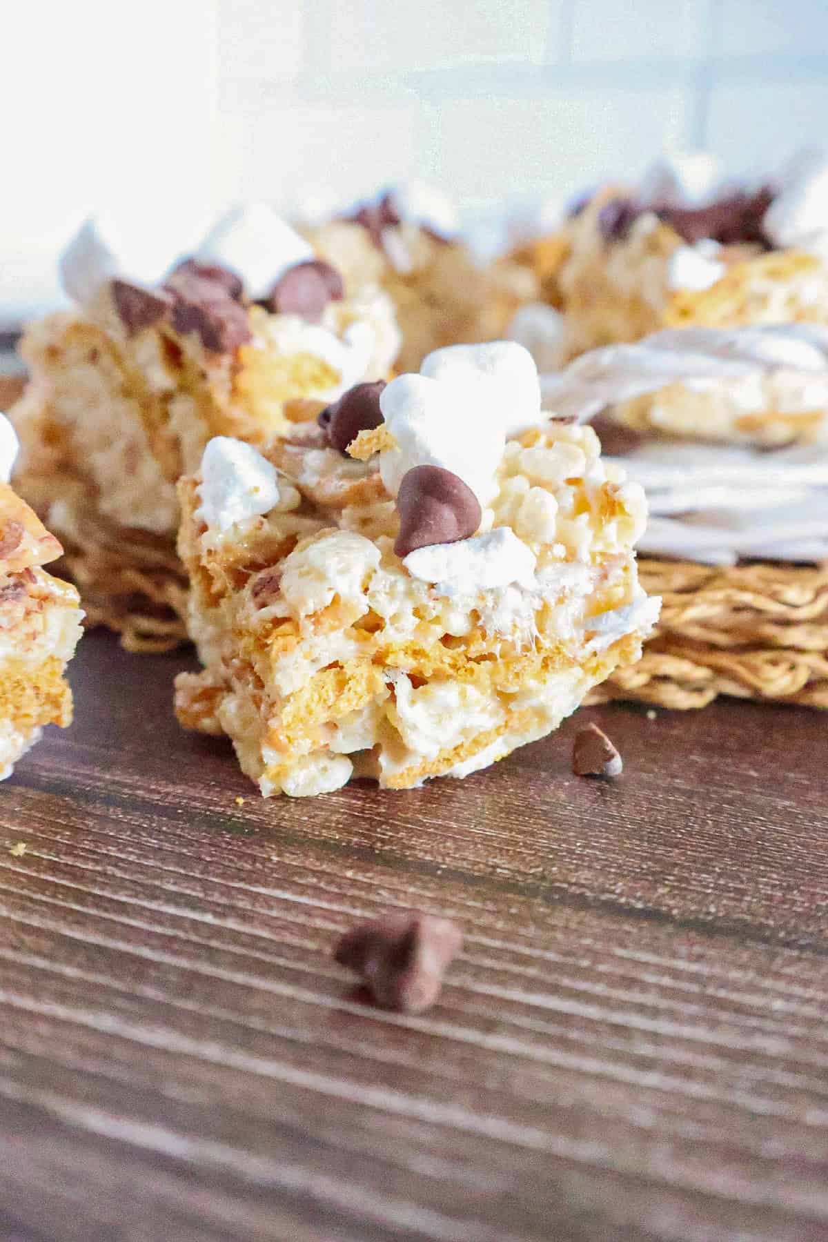 Close-up of a gooey S'mores Rice Krispie treat with melted marshmallows, chocolate chips, and graham cracker pieces.