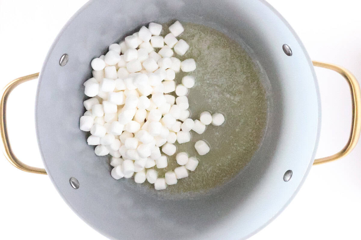 Mini marshmallows melting with butter in a large pot.