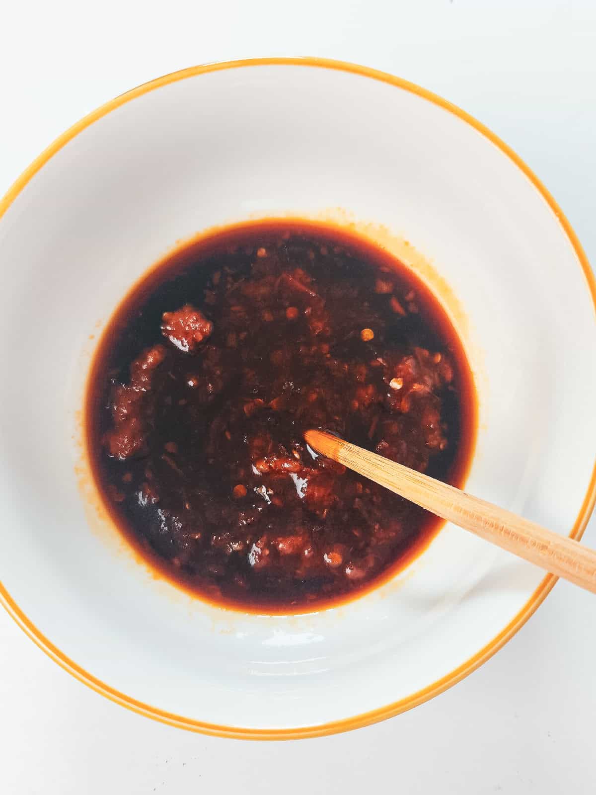 Sambal and soy sauce stirred together to make a flavorful sauce for vegan nasi goreng.