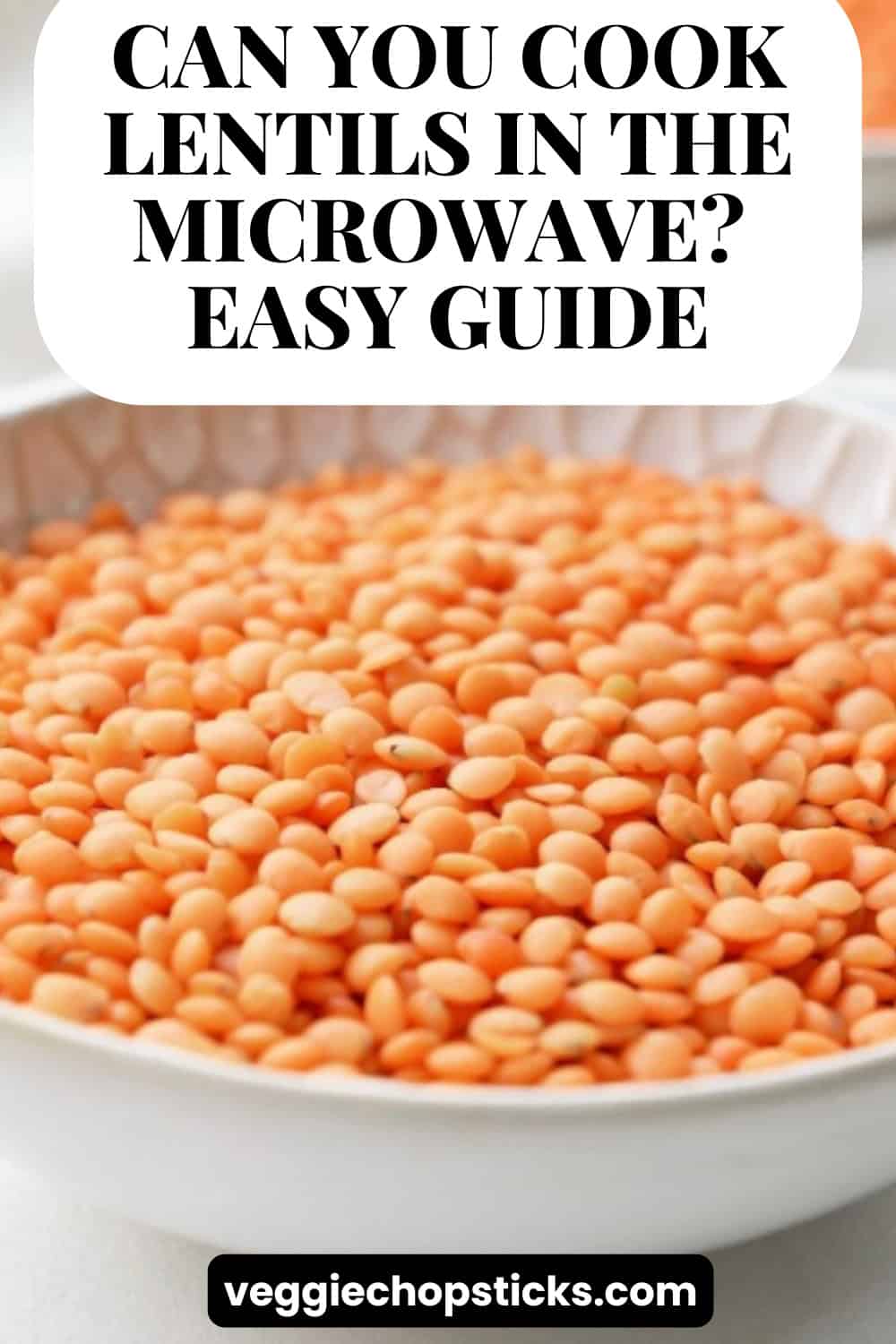 A white bowl filled with dry red lentils on a light-colored surface.