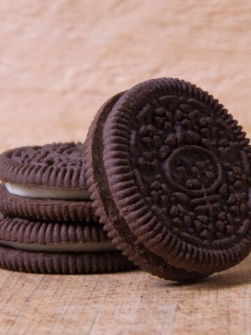 Stack of chocolate sandwich cookies on a wooden tabletop.
