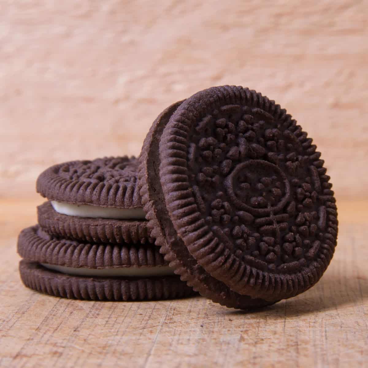 Stack of chocolate sandwich cookies on a wooden tabletop.