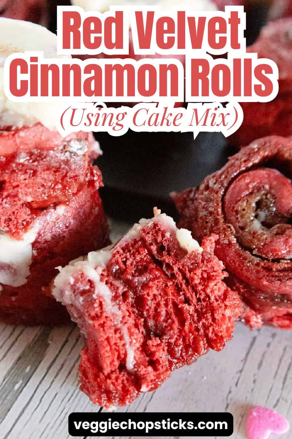 Red velvet cinnamon rolls with cream cheese frosting arranged on a serving board.