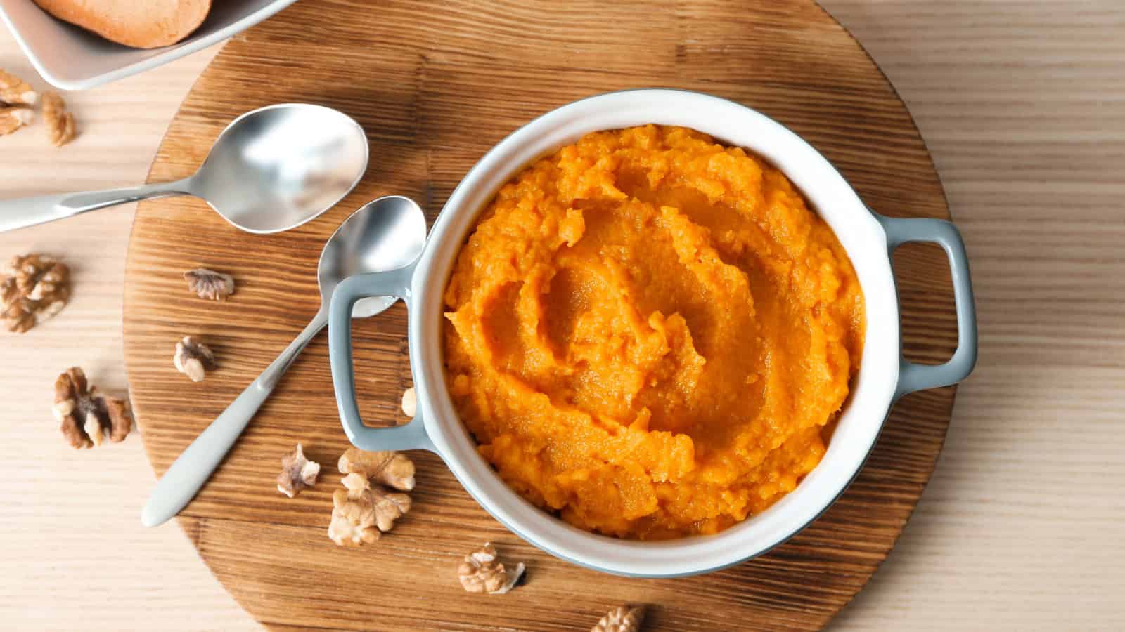Bowl of pumpkin puree on a wooden board.