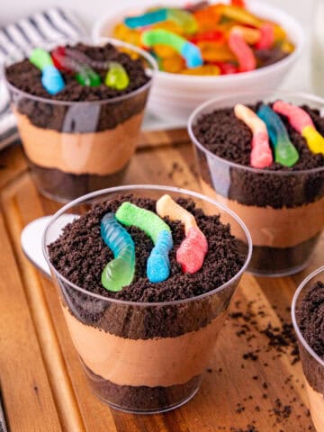 Dirt and worms pudding cups layered with chocolate pudding, Oreo crumbs, and colorful gummy worms.