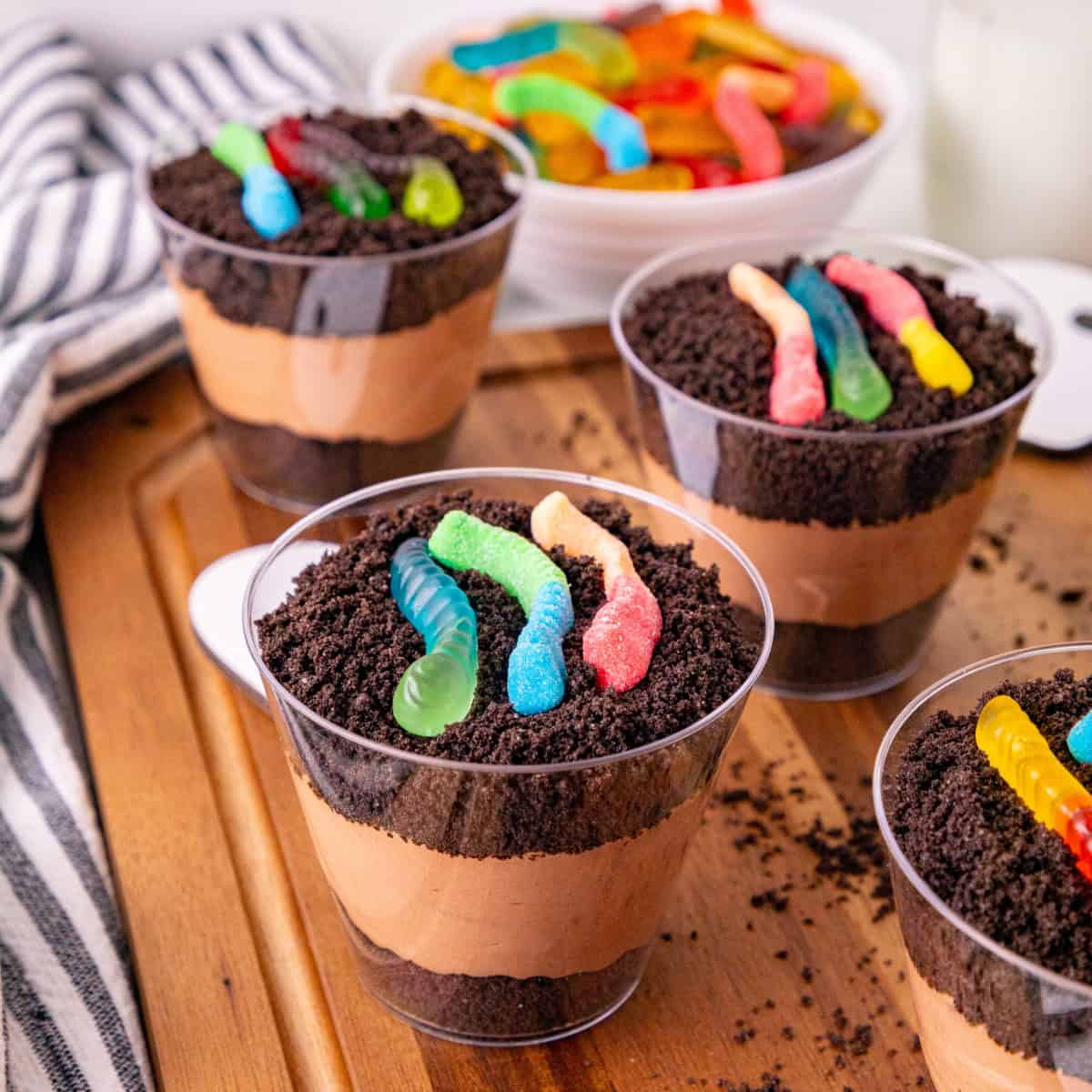 Dirt and worms pudding cups layered with chocolate pudding, Oreo crumbs, and colorful gummy worms.