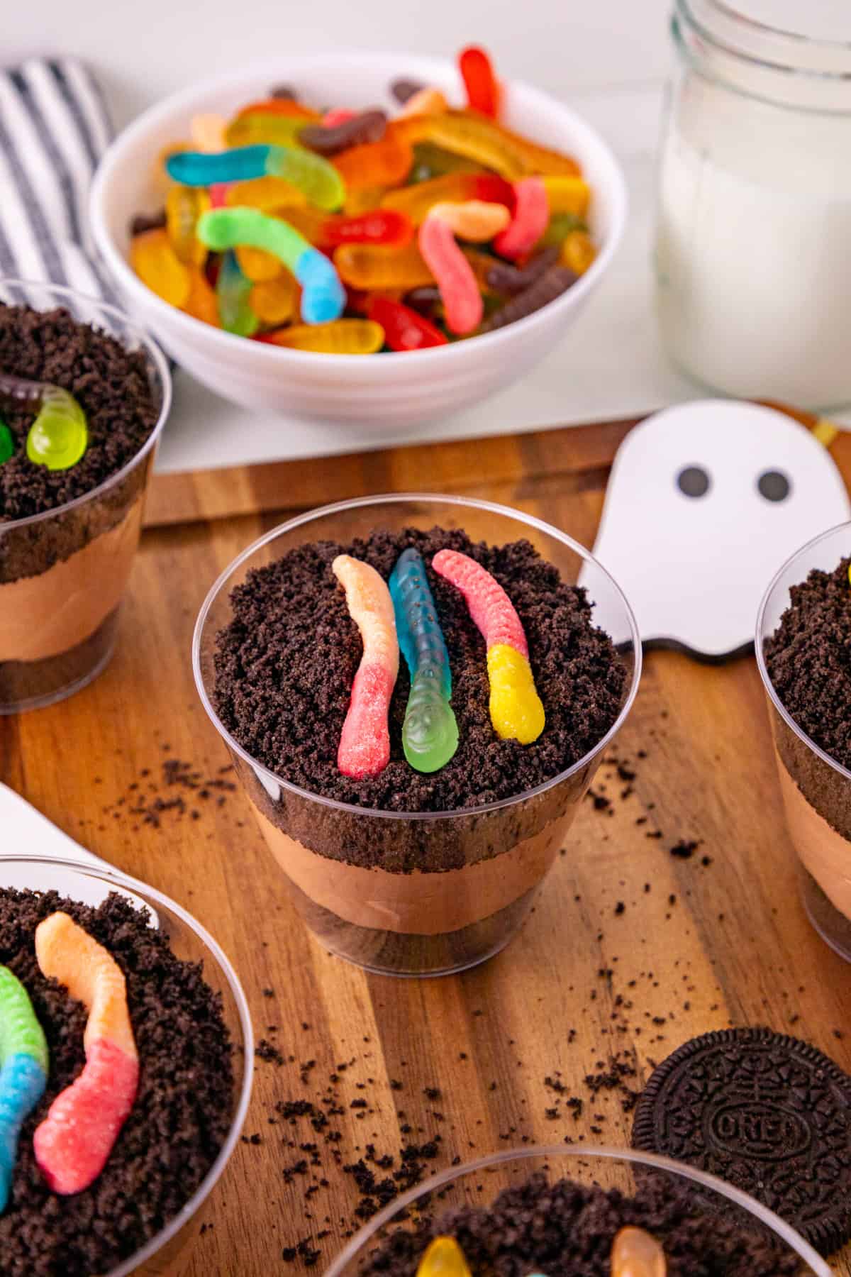 Close-up of a dirt and worms pudding cup with chocolate pudding, Oreo crumbs, and gummy worms.
