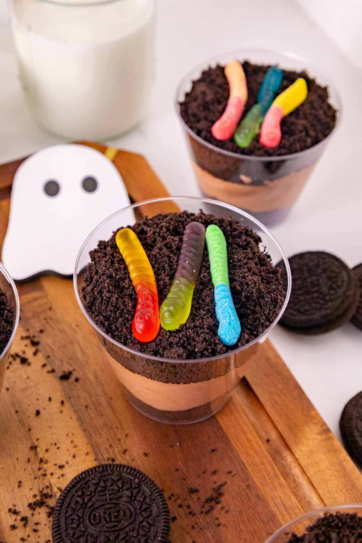 Dirt and worms pudding cup topped with three gummy worms and crushed Oreo cookie crumbs.