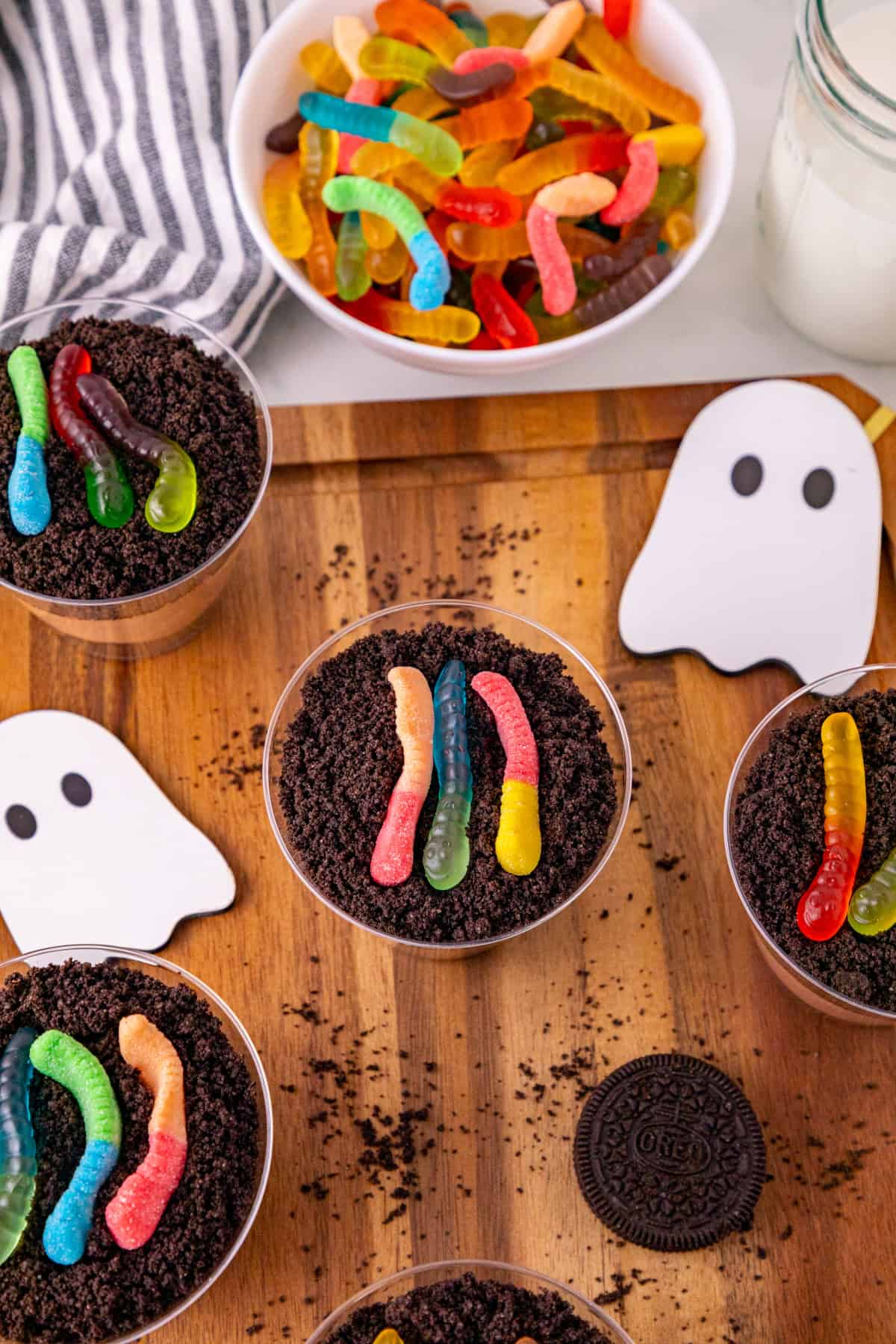 Close-up dirt and worms pudding cup topped with gummy worms and crushed Oreos.