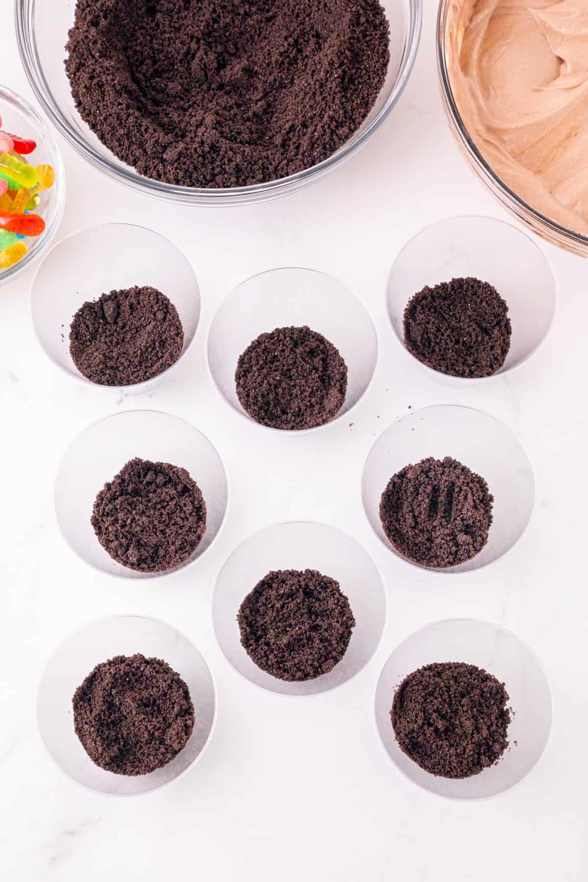 Crushed Oreo cookie crumbs added to the bottom of clear pudding cups.